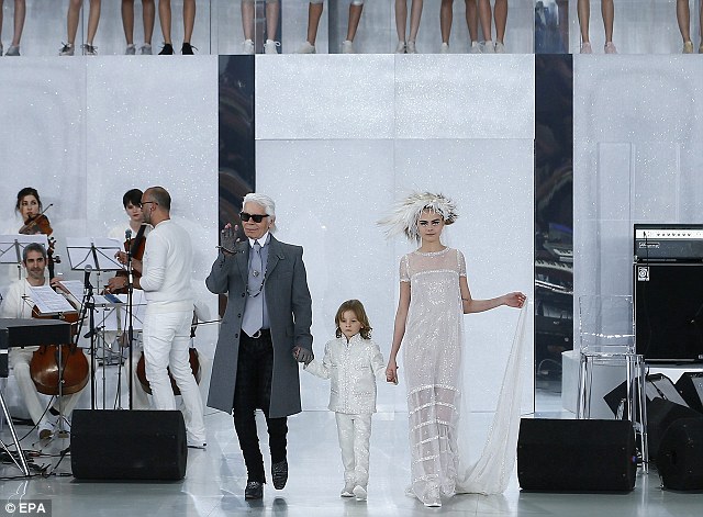 Karl Lagerfeld appears on the catwalk with Cara Delevingne after his SS 2014 Haute Couture collection for Chanel during Paris Fashion Week. The model is one of the 80 year old designer
