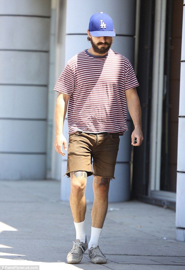Stepping out: The actor sported a generous amount of facial hair, as he shaded his eyes from the sunshine under a blue baseball cap - which also covered his curly brown locks