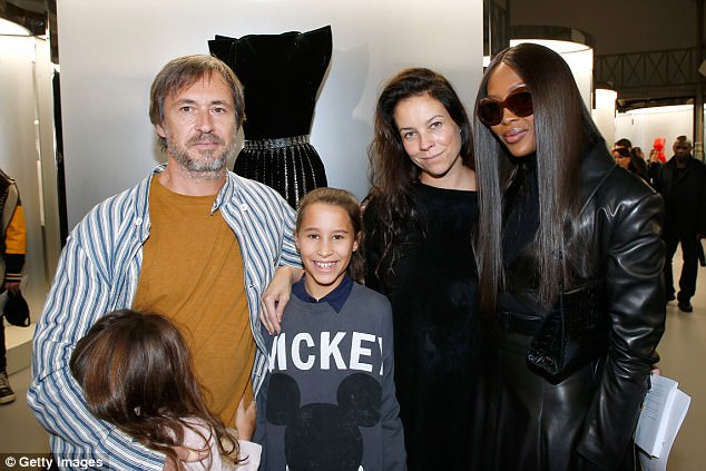 All together: Naomi clutched onto a faux-crocodile skin purse as she perused the stylish exhibit, rubbing shoulders with fashion heavyweights Marc Newson and his family