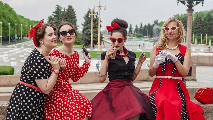 Four woman in long black and red dresses