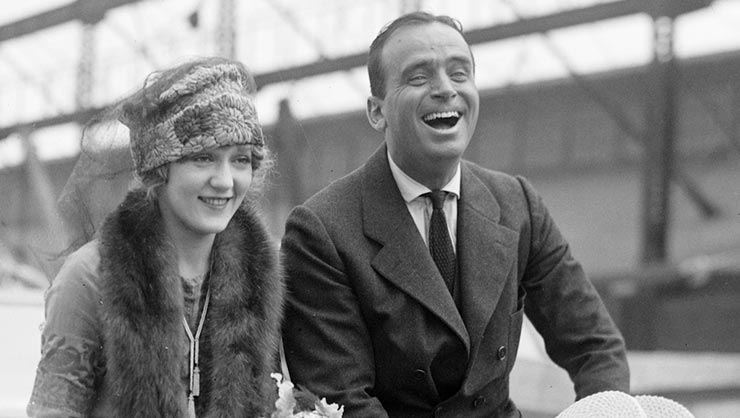 A smiling woman and man in 1920s period clothes