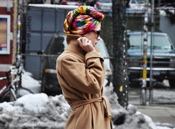 Девушка в бежевом пальто и цветном платке на голове